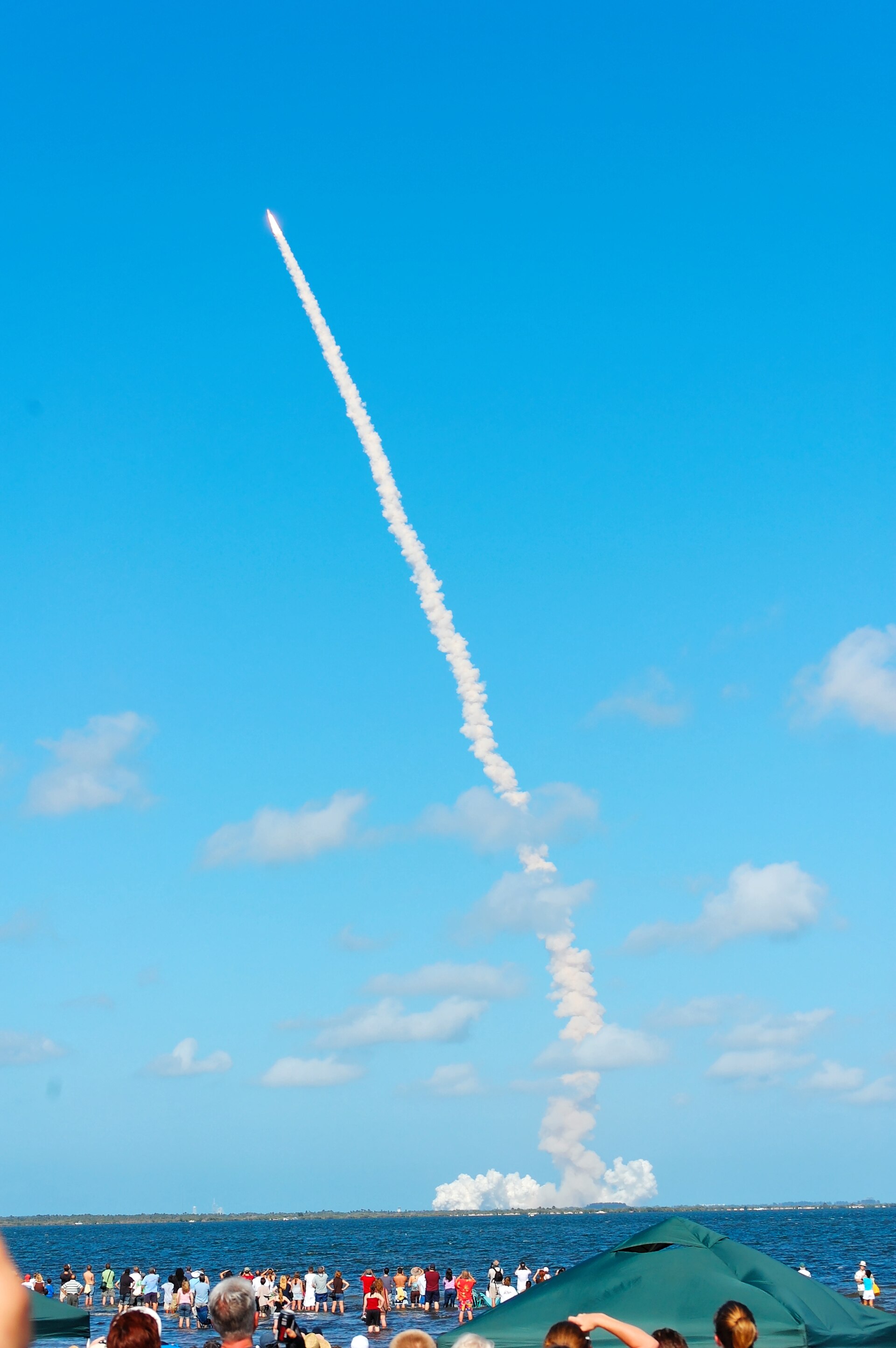 Launch viewed from Space View Park in Titusville, with Kennedy Space Center across the lagoon.